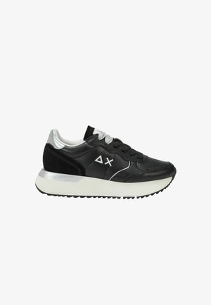 Zwart-zilveren lage sneaker met witte zool, zwarte en zilveren veters en een wit geometrisch logo aan de zijkant.