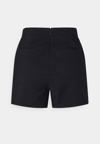 Pantalones cortos negros con una textura suave, que cuentan con cierre de cremallera, dos bolsillos traseros y un diseño ajustado de cintura alta.