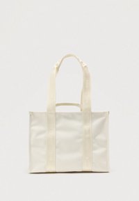 Sac fourre-tout en toile blanche avec deux longues anses et un logo en relief. Le sac présente une forme rectangulaire et une texture lisse.