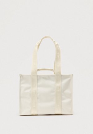 Bolsa tote de lona blanca con dos asas largas y un logo en relieve. La bolsa presenta una forma rectangular y una textura lisa.