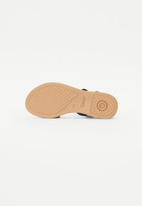 Black shoe sole with a textured surface, featuring a circular accent and a diamond pattern for grip. Brand name "Gabor" embossed on side.