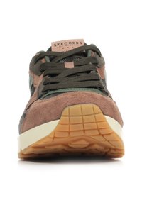 Vue de face d'une sneaker Skechers marron et verte avec des lacets foncés, des détails en suède et en maille, et une semelle en gomme texturée.
