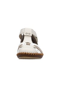 Sandale en cuir blanc avec un bout fermé, une bride ajustable, un design découpé et une semelle en caoutchouc brun cousue. Présente des accents en métal.