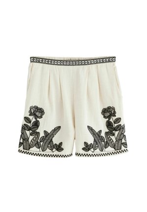 Vita linneshorts med svart blommönster och dekorativ midja. Inkluderar fickor och en avslappnad passform med veck.