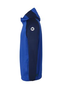 Blauwe jas met een capuchon, voorzien van marineblauwe mouwen. Het materiaal is glad en er staat een logo op de linkerschouder. Inclusief zijzakken.