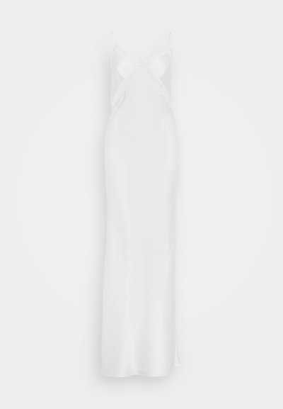 Biely saténový slip šaty s tenkými ramienkami, so V-výstrihom a čipkovým lemovaním okolo dekoltu, dosahujúce dĺžku po členky s bočným rozparkom.