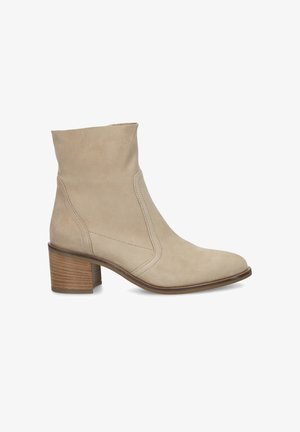 Bottine en daim beige avec un talon bloc en bois empilé, un bout arrondi et une fermeture éclair latérale, présentée de profil, tournée vers la gauche.