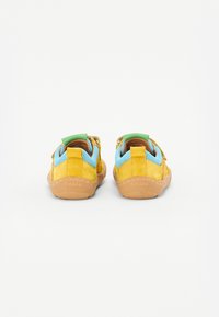 Chaussures pour enfants en daim jaune avec des accents en maille bleu clair. Dispose d'une semelle en caoutchouc et d'un onglet au talon vert pour un enfilage facile.