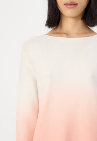 Gebreide sweater met een gradientontwerp dat overgaat van cream naar zacht roze. Het heeft een brede halslijn en een gestructureerde stof.