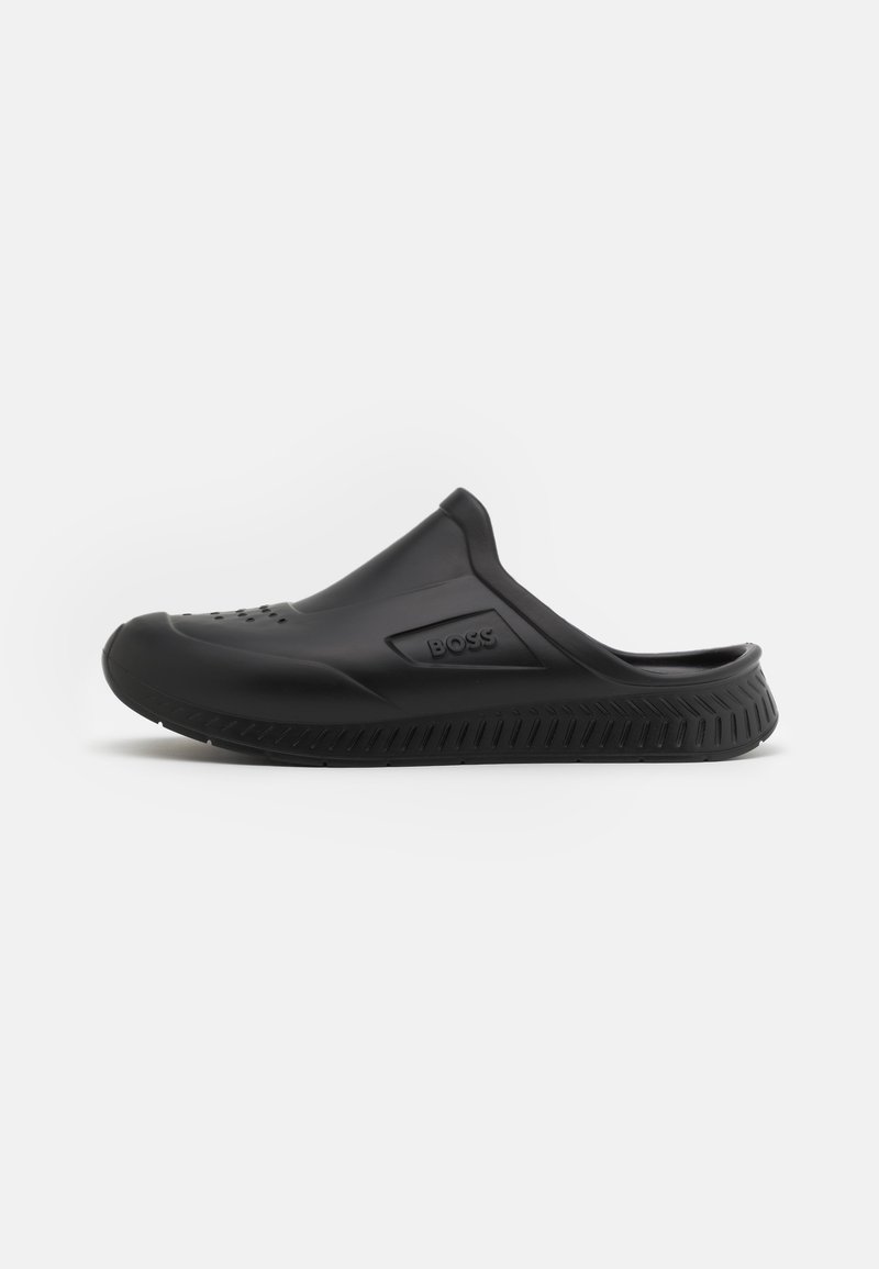 Sabot noir sans lacets avec embout ventilé, semelle texturée et logo "BOSS" sur le côté, conçu pour un usage décontracté ou aquatique.