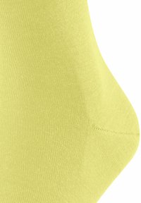 Jasnożółta skarpetka wykonana z gładkiego, elastycznego materiału. Posiada bezszwowy palec oraz dopasowany kształt dla wygody i elastyczności.