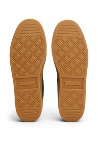 Gummisohlen eines Schuhpaars mit Diamant- und Linienprofilmustern sowie "Tommy Hilfiger"-Markenlogo im Fersenbereich.