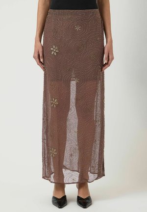 Brun gennemsigtig maxi nederdel med guldperle blomster- og swirlbroderi, båret med sorte spidse sko og top.