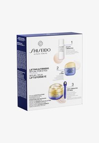 Zestaw do pielęgnacji oczu Shiseido Lifting & Firming w pudełku, zawierający białą butelkę serum, niebieski słoiczek z kremem, złoty słoiczek oraz niebieski aplikator o gładkiej fakturze.