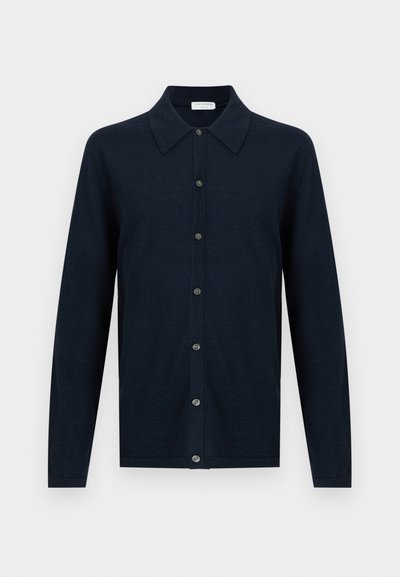 Μακρυμάνικο ζακέτα σε ναυτικό μπλε χρώμα με μυτερό γιακά και κλείσιμο με κουμπιά μπροστά, εμφανίζεται σε λευκό φόντο.