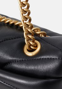 Zwarte leren handtas met een gequilt ontwerp, gouden kettinghengsel en gegraveerde metalen accent met de merknaam "PINKO."