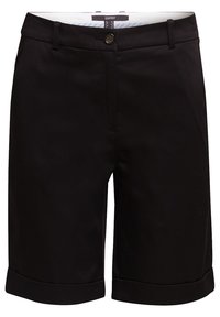 Mustat polvipituiset saparot, joissa on napitus, vyölenkit ja käänteet, suunniteltu muodolliseen tai siistiin rentoon ilmeeseen.