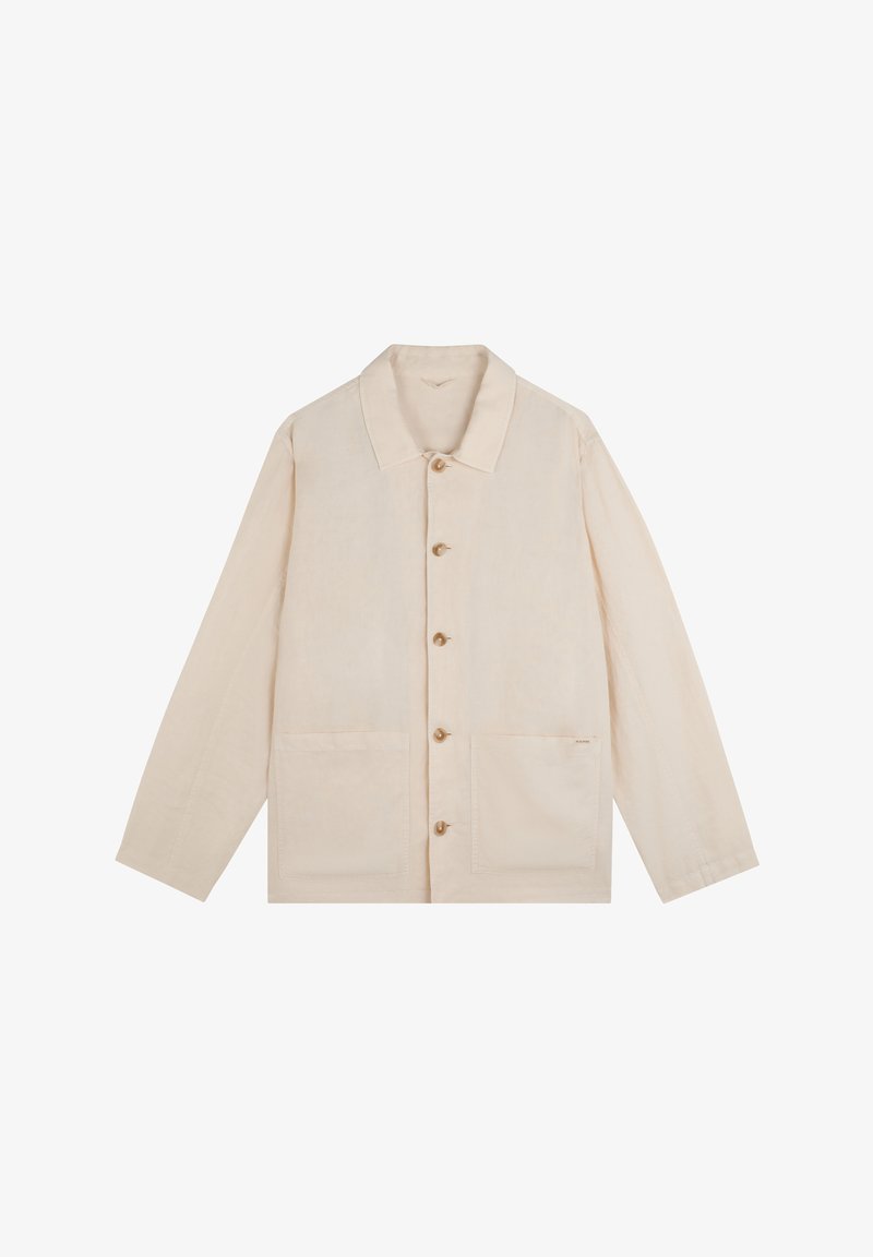 Camisa beige de manga larga con botones, cuello y dos bolsillos delanteros de parche, tendida sobre un fondo blanco.