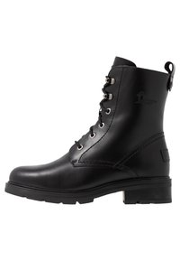 Stivale alla caviglia in pelle nera con punta arrotondata, chiusura con lacci, dettagli a occhiello e suola in gomma strutturata. Presenta un tassello sul tallone.