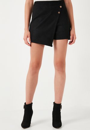 Zwarte suède shorts met een wikkelontwerp, voorzien van twee houten knopen als accenten. De stof heeft een gladde textuur en een op maat gemaakte pasvorm.