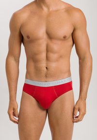 Rode herenbriefs met een grijze elastische tailleband, waarop de merknaam "HANRO" is gedrukt. Slanke pasvorm en zachte stof.
