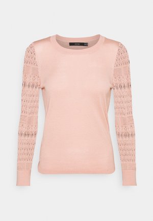 Pull en maille rose clair à col rond, avec un corps uni et de longues manches ornées de motifs ajourés.