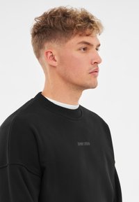 Johnny Urban CARTER OVERSIZED CREWNECK - Felpa - schwarz logo print