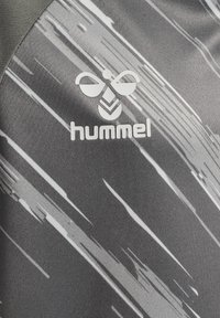 Grå atletisk tröja med diagonala vita streckmönster, med en framträdande vit "hummel"-logotyp på framsidan. Mjukt, texturerat tyg.
