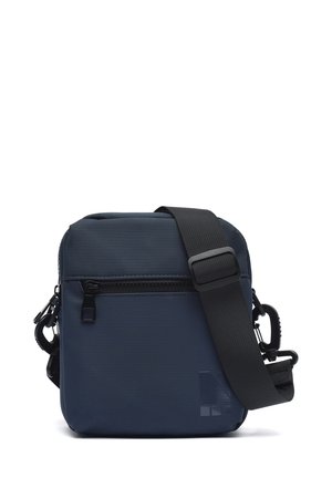 Lille mørkeblå crossbody taske med sort justerbar rem og front lynlåslomme, vist på hvid baggrund.