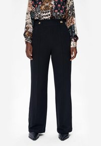 Zwarte wijde broek met een tailored design, voorzien van een hoge taille, plooien aan de voorkant en gouden knoopaccenten. Gladde stoftextuur.