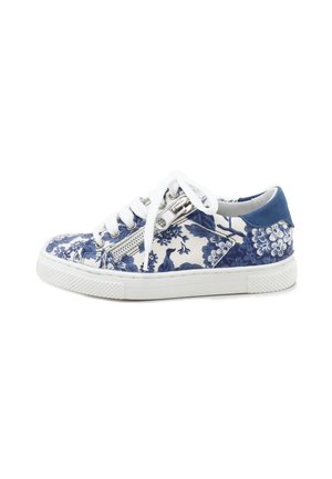 Zapatilla deportiva baja con suela blanca, estampado floral azul y blanco, cordones blancos y cremallera lateral sobre fondo blanco.