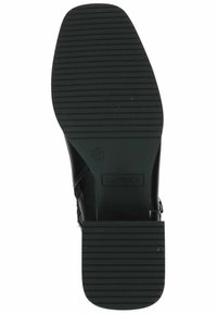 Suela de zapato negra con ranuras horizontales para tracción, con el nombre de la marca "Caprice" y la talla "37" grabados en la superficie.