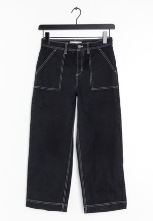 Musta leveälahkeinen housut, joissa on kontrastivalkoinen ommel, useita etutaskuja, nappikiinnitys ja sileä denimmateriaali.