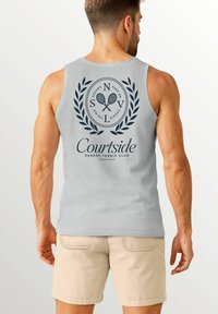 Gray sleeveless shirt featuring a circular logo with tennis rackets and laurel accents, labeled "Courtside Sunday Tennis Club."