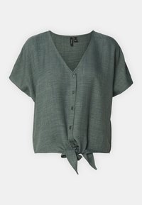 Blouse verte à manches courtes avec un col en V, dotée d'une fermeture à boutons sur le devant et d'un nœud noué à l'ourlet. Fabriquée en tissu texturé.