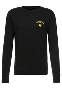 Felpa nera con collo a giro e maniche lunghe, con un piccolo logo giallo "Barbossa Shop" che raffigura un volto barbuto sul lato sinistro del petto.