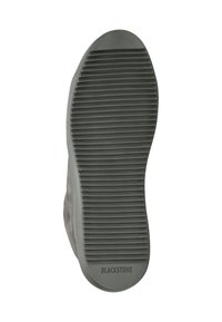 Suola di scarpa in gomma di colore grigio scuro, con scanalature orizzontali testurizzate per una migliore aderenza. Presenta il marchio "BLACKSTONE" vicino al tallone. Design della punta arrotondata.