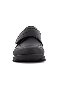 Zapato de cuero negro con parte superior texturizada, suela de goma resistente y una banda de Velcro en la parte delantera. Nombre de la marca "Pablosky" visible.