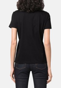 T-shirt nera a maniche corte in cotone, con una vestibilità rilassata e una texture liscia, dal design semplice e senza motivi.