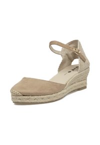 Zapato cuña de esparto beige con parte superior de ante y textura tejida en la correa del tobillo. Presenta una punta redondeada y una suela intermedia de yute trenzado.
