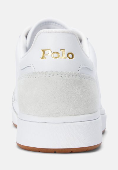Balti odiniai sportbačiai su pilku zomšiniu kulno akcentu, su auksiniu "Polo" logotipu. Elnio raštuotas gumos padas, o viršus yra lygus.
