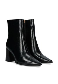 Stivaletti neri in pelle con punta affilata e tacco a blocco. Texture liscia con dettaglio di cerniera laterale e finitura elegante.