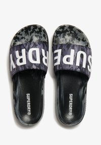 Zwarte en grijze schuifsandalen met een gestructureerde band met "SUPERDRY" in het wit. Geprint bovenwerk en gladde binnenvoering voor comfort.