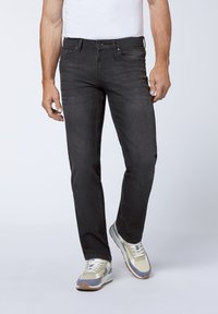 Dark grey denim jeans with a straight leg fit, five-pocket design, and minimal fading, paired with multi-colored sneakers.