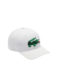Gorra de béisbol blanca con un logotipo de cocodrilo bordado en verde en la parte frontal. Tiene un visera curvada y una tela texturizada.