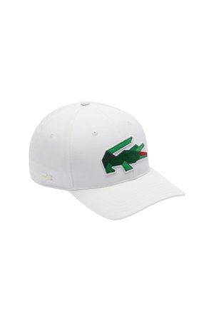 Gorra de béisbol blanca con un logotipo de cocodrilo bordado en verde en la parte frontal. Tiene un visera curvada y una tela texturizada.