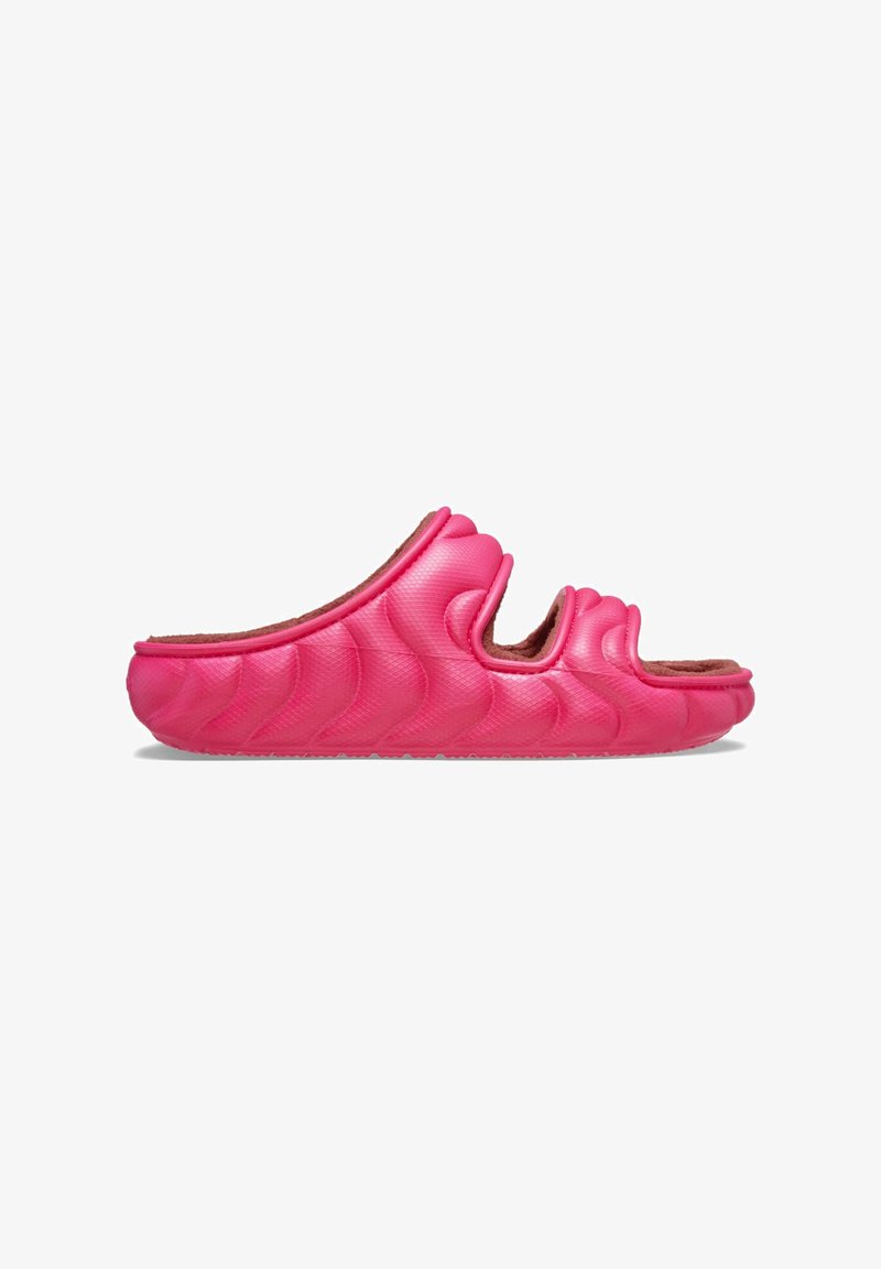 Sandalia de slide moldeada en color rosa con un patrón ondulado, que presenta un upper texturizado y un suave forro interior. Diseño de punta abierta, suela plana.