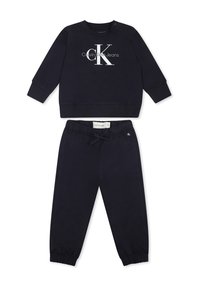 Sudadera azul marino de manga larga con el logo blanco de "Calvin Klein Jeans". Pantalones jogger a juego en azul marino con puños y cinturilla elástica.