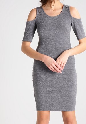 Robe en maille grise avec découpe aux épaules dénudées, manches courtes, silhouette ajustée et texture subtilement scintillante. Coupe mi-longue.