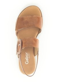 Brown leather sandal with wide straps and a buckle accent. Cushioned insole and low heel design for comfort. Gabor branding on the sole.